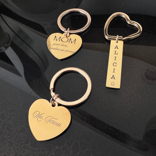 Llavero en forma de corazón grabado por ambos lados, personalizado con nombres y frases. Asa redonda dorada y plateada. Llavero dorado con asa en forma de corazón y placa rectangular para grabado personalizado con láser.