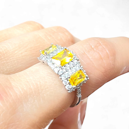 Anillo de bisutería ajustable con piedras tipo circonia amarillas y acabado plateado
